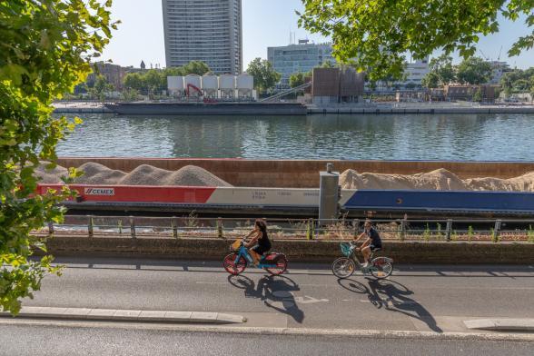 Scène de vie sur les quais du port de Javel à Paris. Passage de cyclistes devant des barges de fret CEMEX. - Agrandir l'image, fenêtre modale
